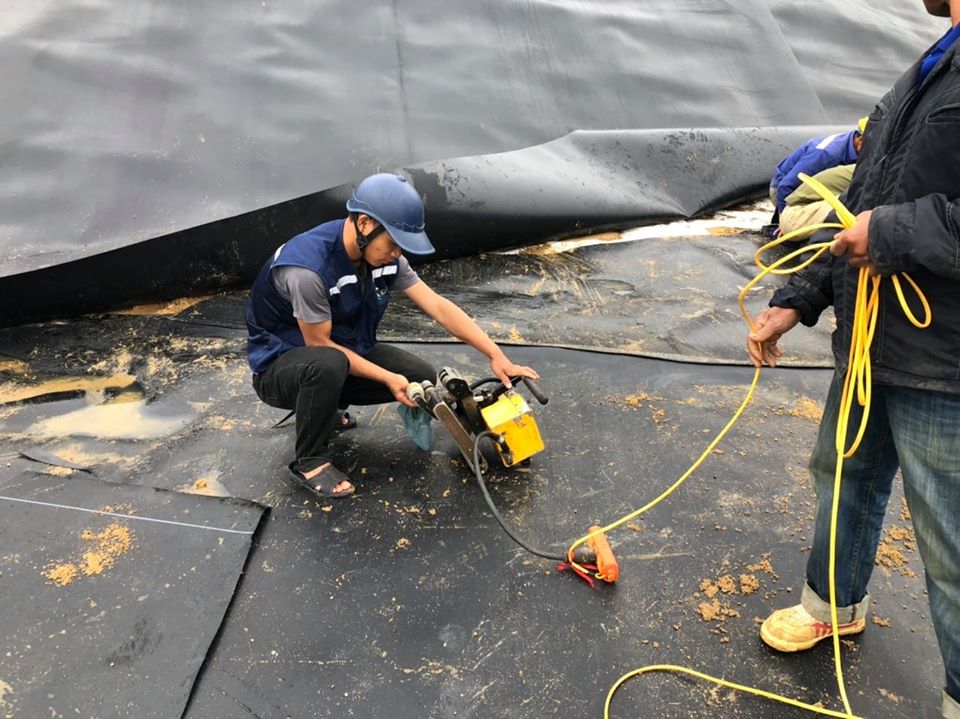 Kỹ thuật viên BIogas Việt Nam đang thi công hàn nối màng chống thấm HDPE tại công trường